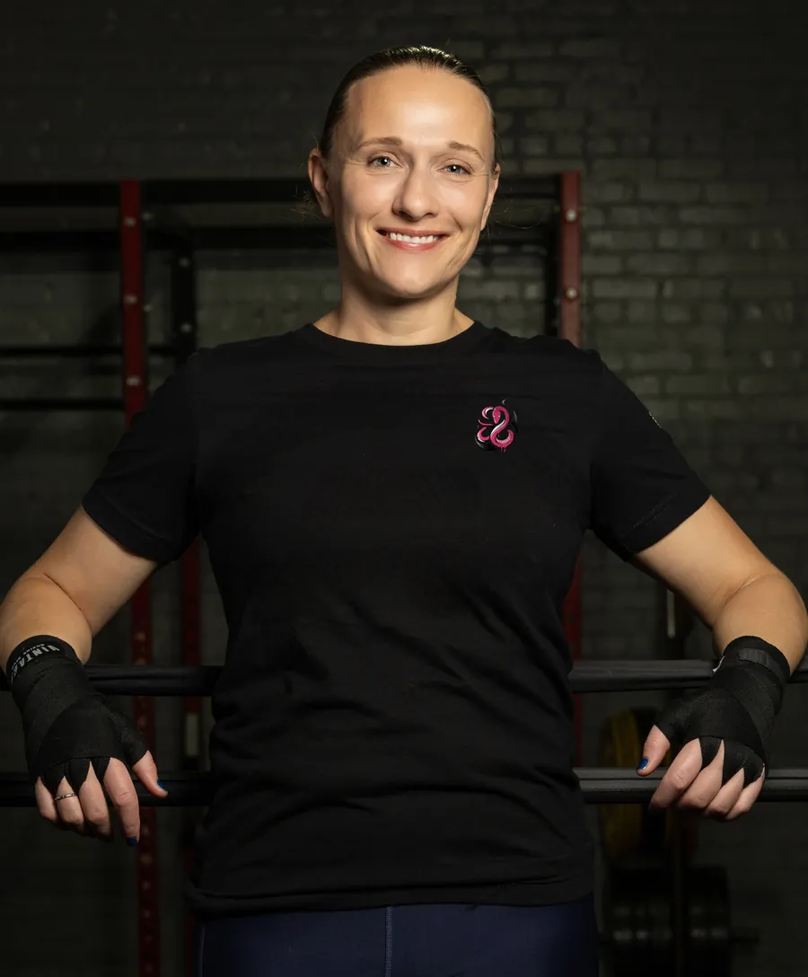 Carmen &ldquo;The Momba&rdquo; Gulliksen in profile against a red-lit brick wall